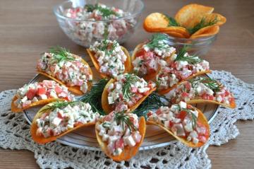 Vorspeise Salat mit Krabben-Sticks auf Chips für das neue Jahr